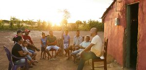 dez pessoas sentados em meia lua conversando sobre o projeto escolas do sertão ao pôr do sol