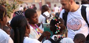 roberto pascoal, empreendedor social e mentor da omunga mostrando livros à crianças negras em situação de vulnerabilidade social