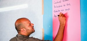 roberto pascoal, empreendedor social da omunga, escreve em cartolina rosa e leva transformação social por meio da educação